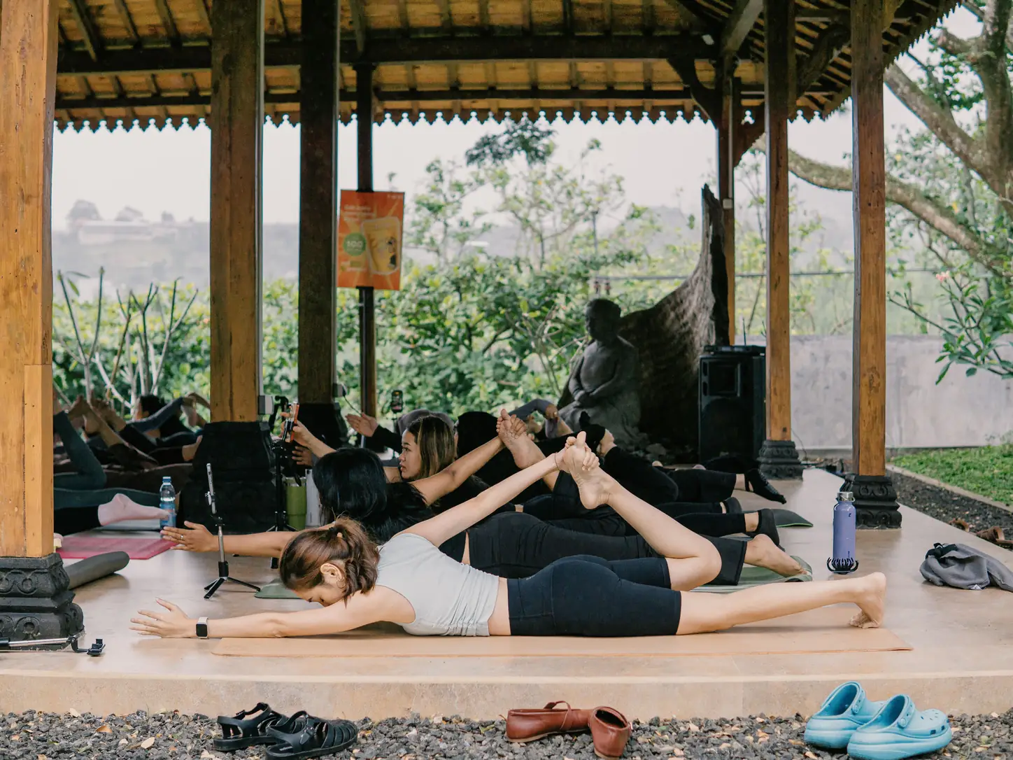 A group practicing yoga in an open-air pavilion.